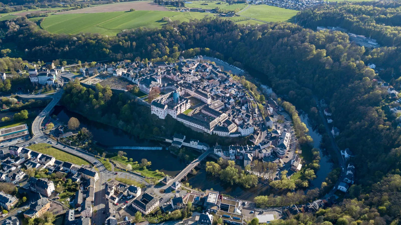 Luftbild von Weilburg mit Schloss, Altstadt und Lahnschleife in der Abendsonne