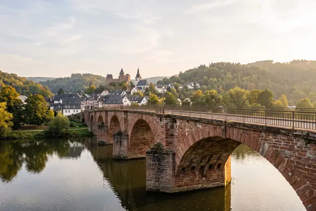 Illustratives Motiv: Alte Sandsteinbogenbrücke über die Lahn mit Pfeilern und Bogenunterseiten im Nachmittagslicht
