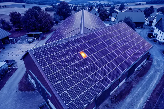 Illustratives Wärmebild: Wärmebild einer Photovoltaikanlage auf einem Scheunendach, ein Modul zeigt einen hellen Hotspot