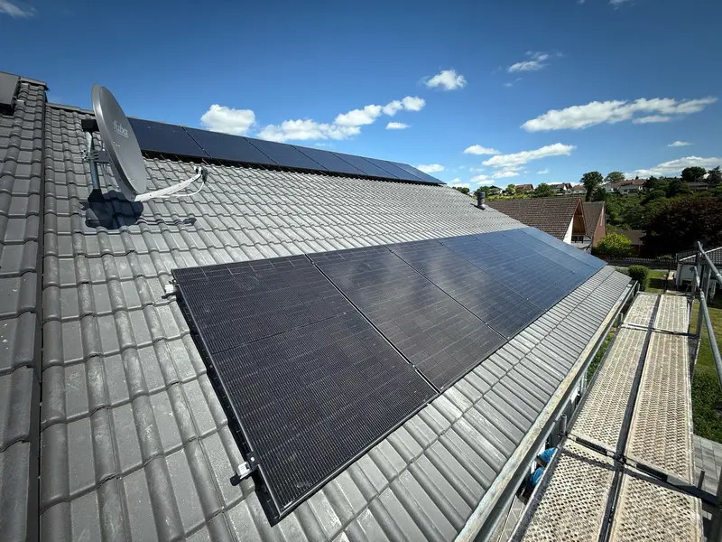 Solarmodule auf einem Ziegeldach, rechts der Gerüstbelag